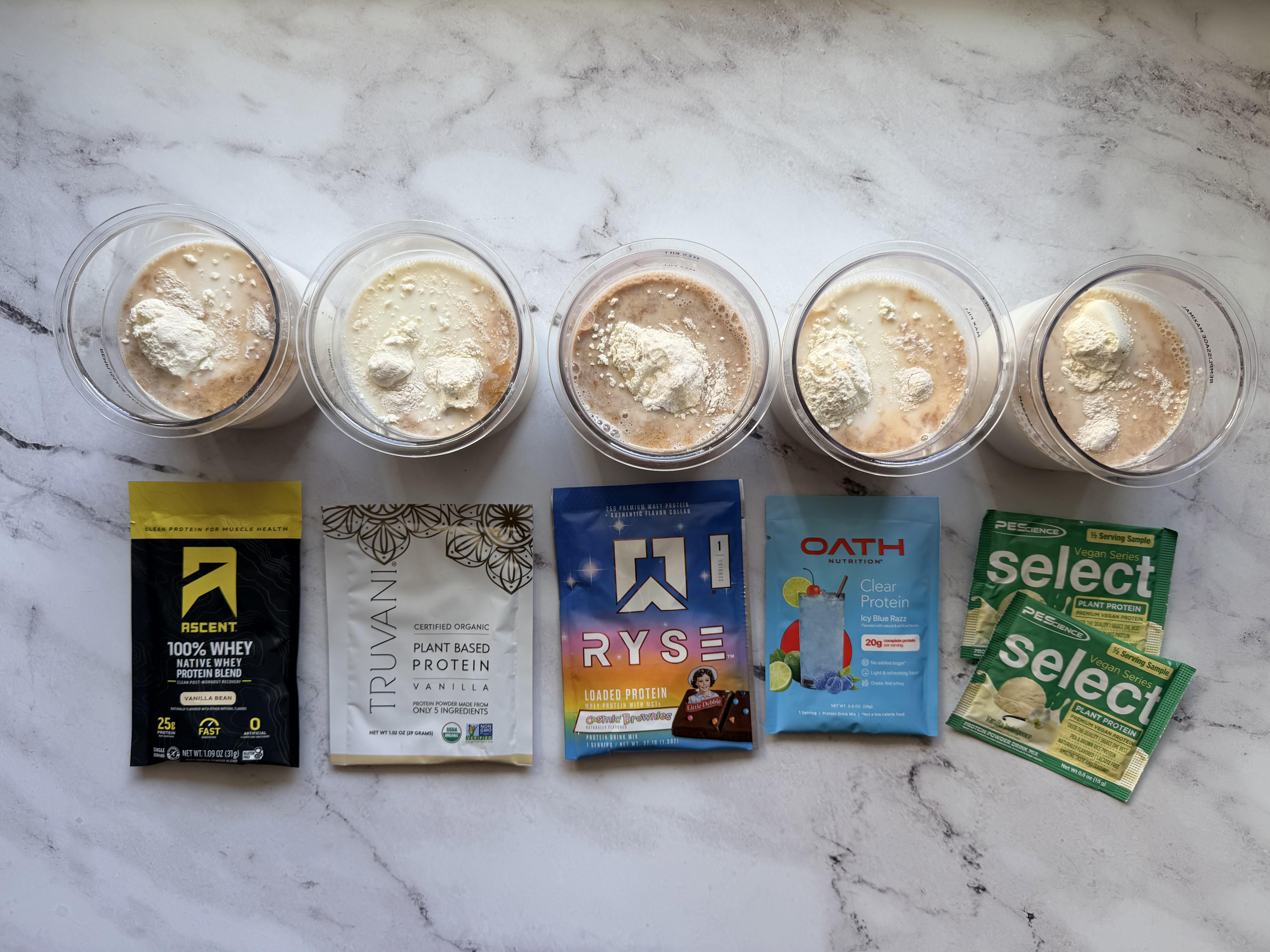 Five Ninja Creami pints lined up with their corresponding protein powder sample packets — Ascent, Truvani, RYSE, Oath, and PEScience
